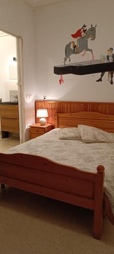 a bedroom with a bed with a wooden bed frame at Le moulin de vaux in Nochizé