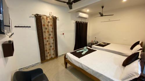 a hotel room with two beds and a window at KAVIEYA Residency in Pūrnānkuppam