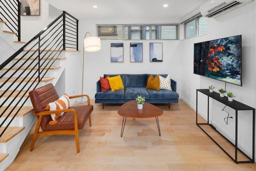 a living room with a blue couch and a table at Perch - Centro House A in Seattle