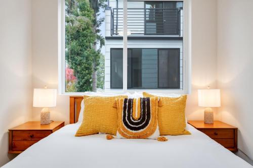 a bedroom with a bed with yellow pillows and a window at Perch - Ballard Bliss in Seattle