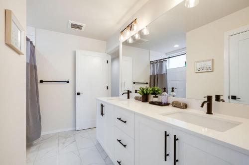 a white bathroom with a sink and a mirror at Perch - Ballard Bliss in Seattle