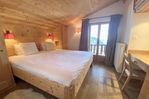 a bedroom with a bed and a desk and a window at Roxes 6 in Bagnes