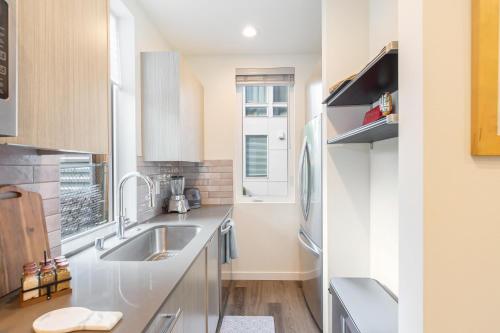 a kitchen with a sink and a refrigerator at Perch - Roosevelt Retreat in Seattle