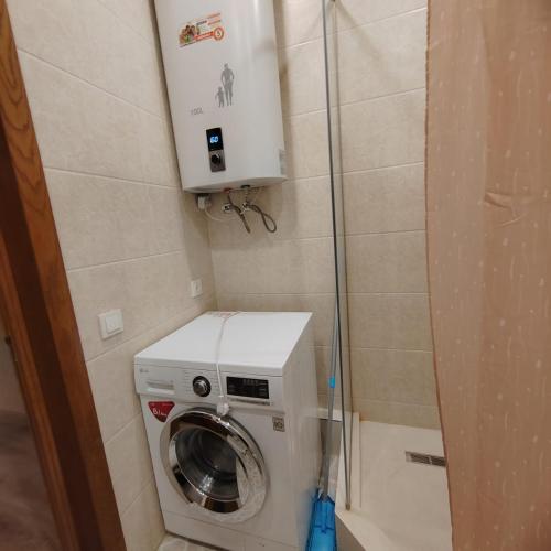 een wasmachine en droger in een kleine badkamer bij 1 bedroom apartment in Doesjanbe