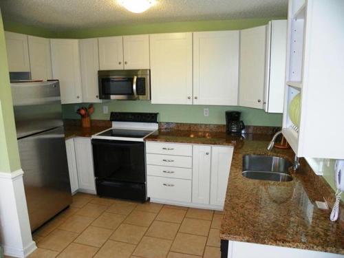 a kitchen with white cabinets and a black appliances at KH5203- Katmantoo in Kitty Hawk