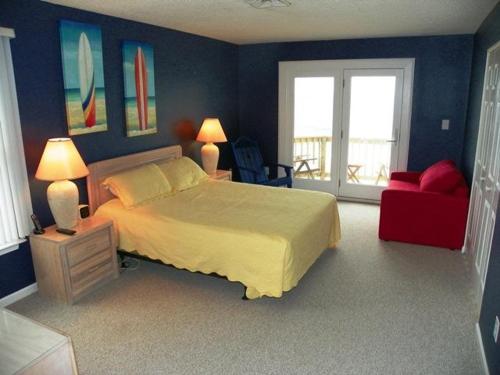 a bedroom with a large bed and a red chair at KH5203- Katmantoo in Kitty Hawk