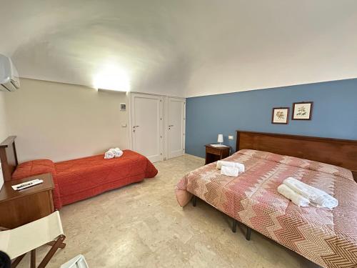 a bedroom with two beds and a table and a desk at Historic B&B Apartments Home in Chiaramonte Gulfi