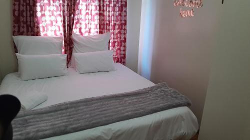 a bedroom with a bed with white sheets and pillows at 9 Spiritual Fruits in Durban