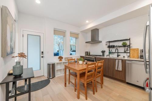 a kitchen and dining room with a wooden table and chairs at Perch - Sand Point Haven in Seattle