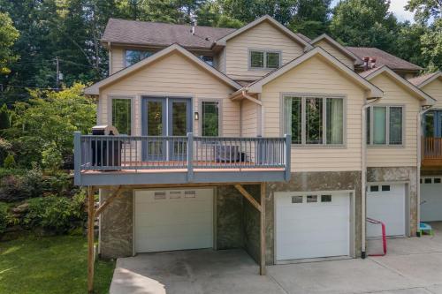 a house with a balcony and two garage doors at Brevard Basecamp in Brevard