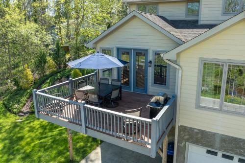a deck with an umbrella and a table and chairs at Brevard Basecamp in Brevard