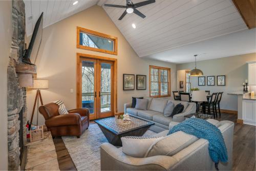 a living room with couches and a table at Canopy Creek Connestee Falls in Brevard