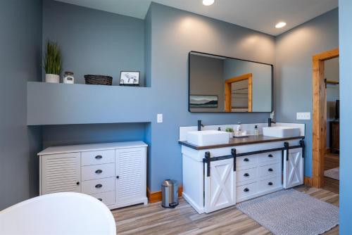 a bathroom with two sinks and a mirror at Canopy Creek Connestee Falls in Brevard
