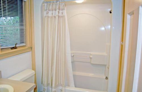 a white bathroom with a shower and a sink at M906- Castle De La Mar in Corolla