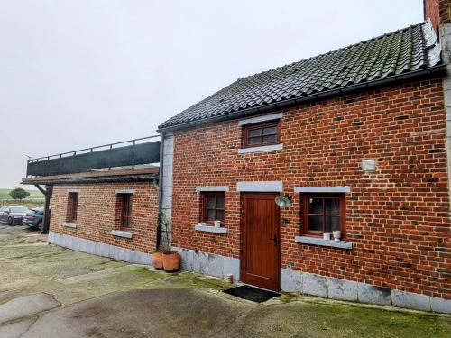 a brick building with a brown door and windows at Le Gite des Croisettes in Les Croisettes