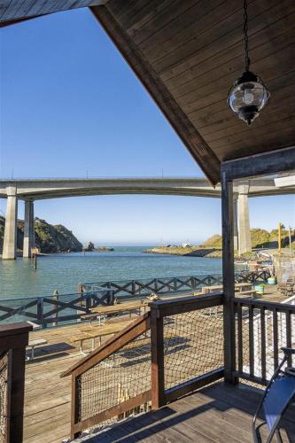 una terraza con vistas al agua y al puente en Harbor Watch, en Fort Bragg