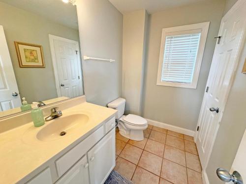 a bathroom with a sink and a toilet and a mirror at KD202- "St. Somewhere" at Playa Del Ray in Kill Devil Hills