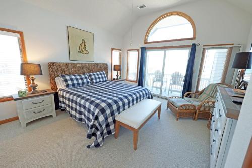 a bedroom with a bed with a blue and white checkered blanket at OH1200-Spyglass in Corolla
