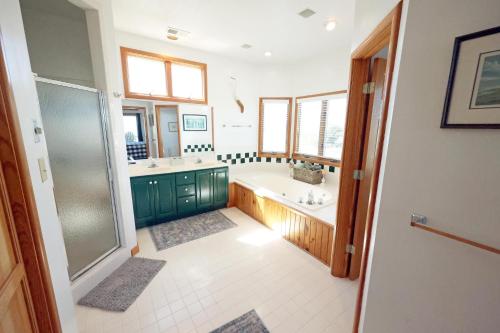 a bathroom with a tub and a sink and a shower at OH1200-Spyglass in Corolla