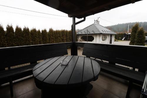 a wooden bench on a balcony with a table at VIP House in Mykulychyn