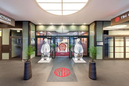 a lobby of a building with two snoopyidents in front of the door at NH Collection Berlin Mitte am Checkpoint Charlie in Berlin