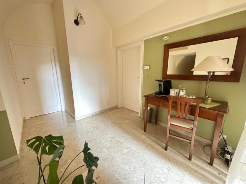 a room with a desk with a lamp and a mirror at Historic B&B Apartments Home in Chiaramonte Gulfi