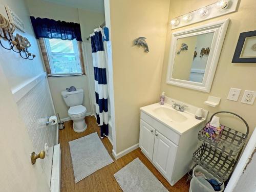 a bathroom with a sink and a toilet and a mirror at KH4300- Weather Station in Kitty Hawk