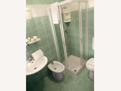 une salle de bains avec lavabo, douche et toilettes dans l'établissement Residence Carina, à Bibione