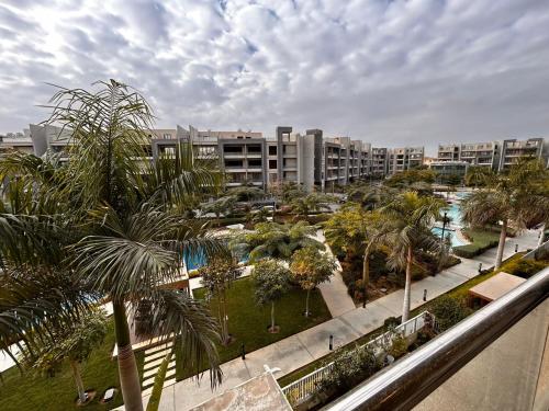 a view of a park with palm trees and buildings at Serene City Stay next to the AUC, New Cairo in Cairo