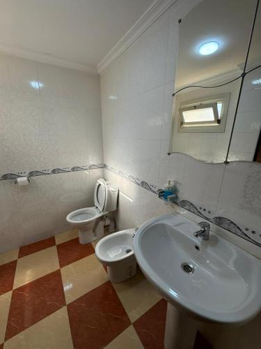 a bathroom with a sink and a toilet and a mirror at joli appart avec terrasse au centre ville in Tetouan