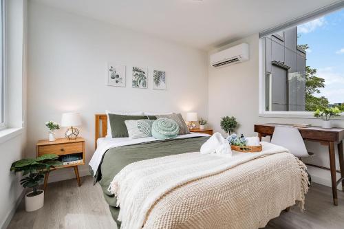 a bedroom with two beds and a desk and windows at Perch - Urban Reflection 18 in Seattle