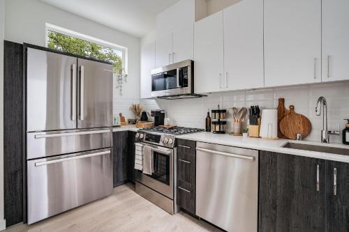 a kitchen with white cabinets and stainless steel appliances at Perch - Urban Reflection 18 in Seattle