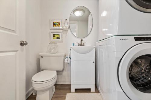 a white bathroom with a toilet and a washing machine at Pinnacle Port 304A in Panama City