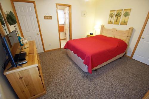 a bedroom with a bed with a red comforter at KH4004- Paradise in Kitty Hawk