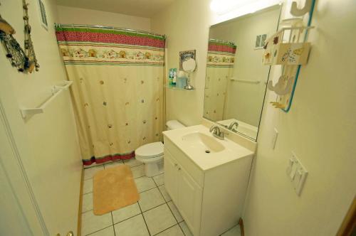a bathroom with a sink and a toilet and a mirror at KH4004- Paradise in Kitty Hawk