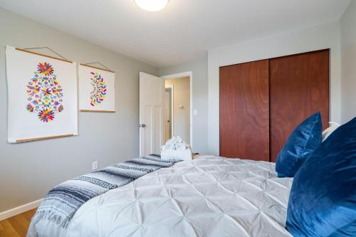 a bedroom with a large white bed with blue pillows at Perch - Shoreline Gathering Spot in Shoreline