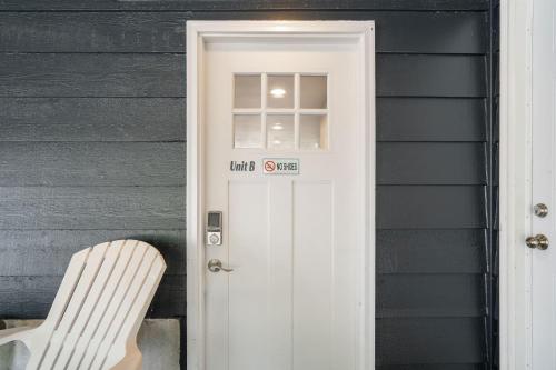 a white door to a house with a white chair at Perch - Shoreline Gathering Spot in Shoreline