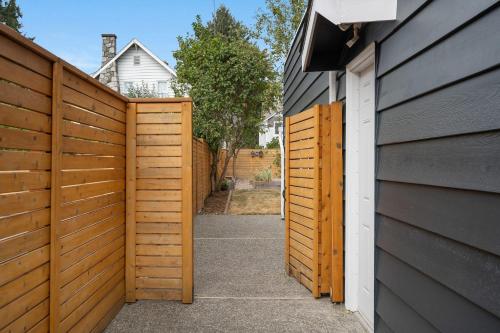 a wooden fence next to a house with a driveway at Perch - Shoreline Gathering Spot in Shoreline