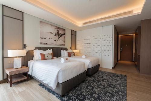 a hotel room with a large bed and a table at ANGSANA Oceanview apartments with jacuzzi in Laguna area in Bang Tao Beach
