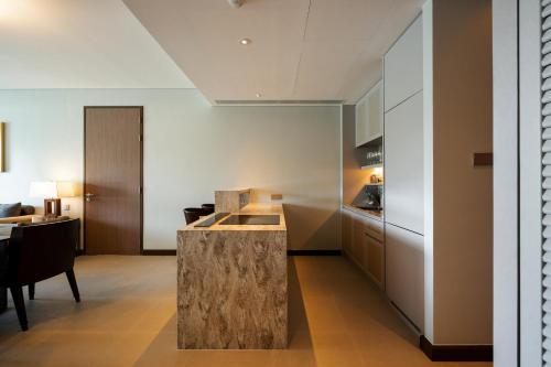 a kitchen with a stone island in the middle of a room at ANGSANA Oceanview apartments with jacuzzi in Laguna area in Bang Tao Beach