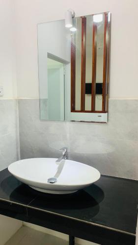 a white sink on a black counter with a mirror at Meridian Holiday Resort in Ratnapura