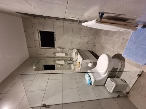 a bathroom with a toilet and a sink and a mirror at Casa Cardumen - Ciudad Del Mar, in Jaco in Jacó