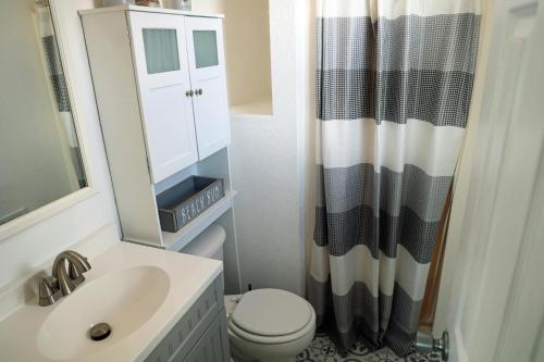 a bathroom with a sink and a toilet and a mirror at SN8421- Sandpiper in Nags Head