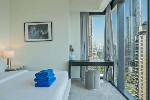 a bedroom with a bed and a desk and a large window at NewArabian Act Two T2 2 BR and 3 BR in Dubai