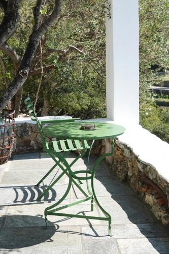 a green table and a chair on a patio at SKYROS REFUGE in Skiros
