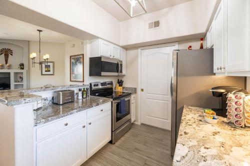 a kitchen with white cabinets and a stainless steel refrigerator at Little Fountain in Fountain Hills