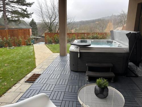 a jacuzzi tub in a yard with a table at Hello Pilis Apartments in Pilisszentkereszt
