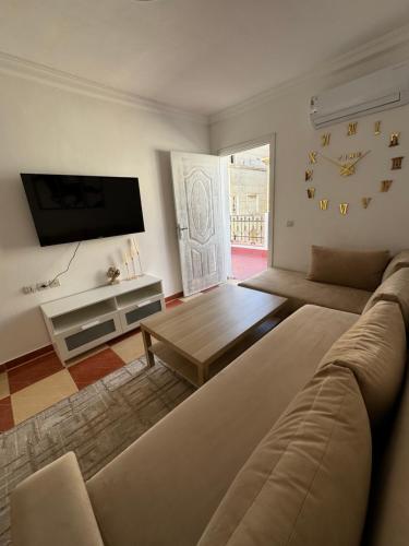 a living room with a couch and a flat screen tv at joli appart avec terrasse au centre ville in Tetouan