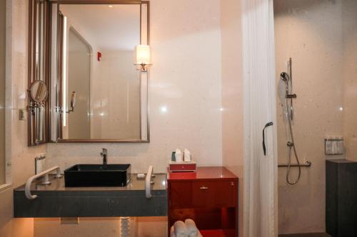 a bathroom with a sink and a mirror at HUALUXE Shenzhen Bao'an in Shenzhen