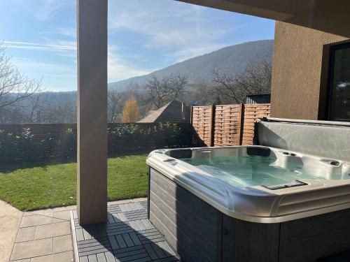 a hot tub on a patio with a view of a mountain at Hello Pilis Apartments in Pilisszentkereszt